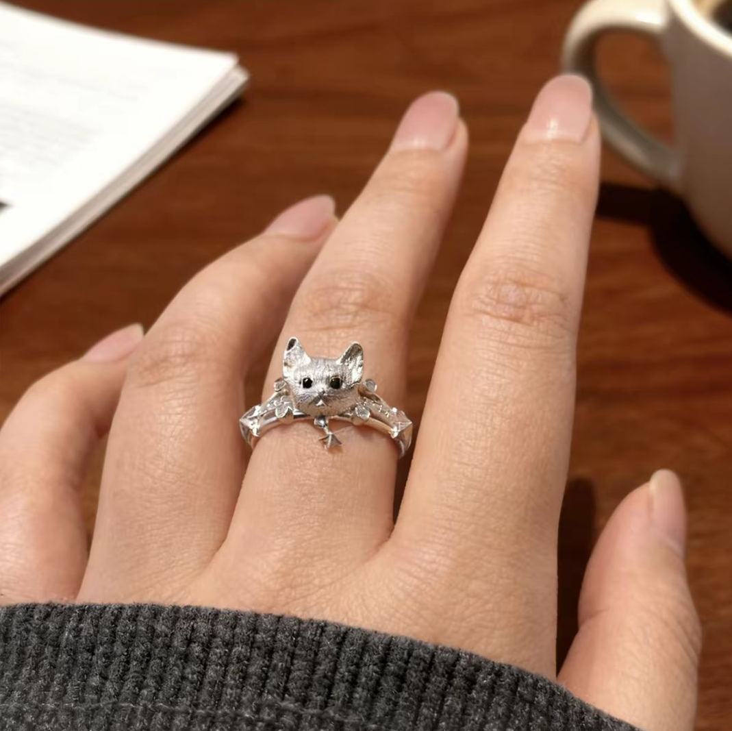 A 925 sterling silver cat ring with a star pendant, worn on a model's finger—an ideal gift choice for cat lovers.